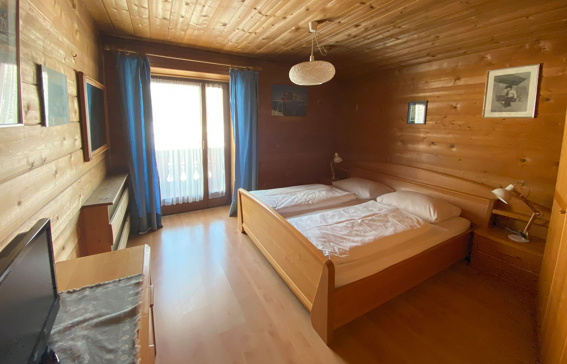 Luminosa camera da letto con rivestimento in legno e accesso al balcone nell'appartamento Tipo A di SASKIA Apartments